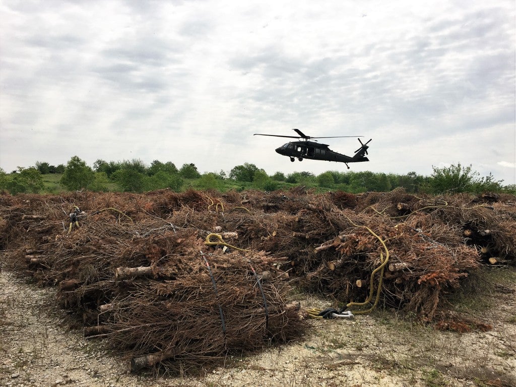 Blackhawk Helicopter picks up a bundle of Christmas trees.
