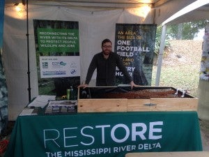 Philip Russo shows off with the Restore the Mississippi River Delta coalition's diversion model at the Plaquemines Orange Festival.