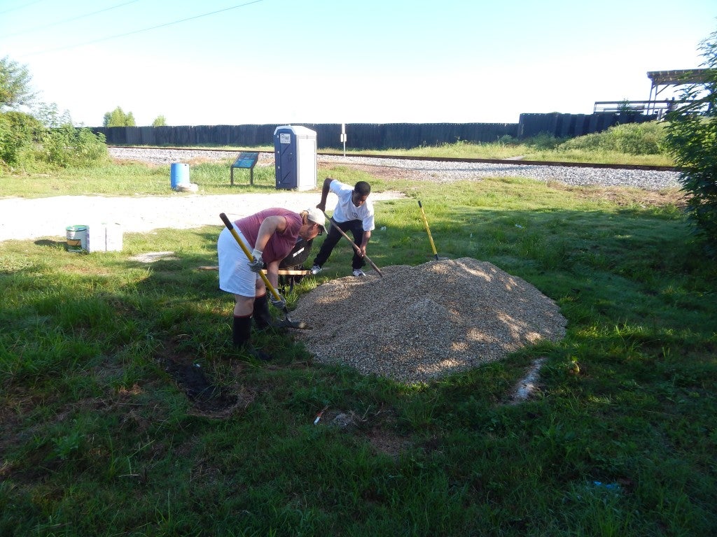 Shoveling gravel to restore the viewing area.